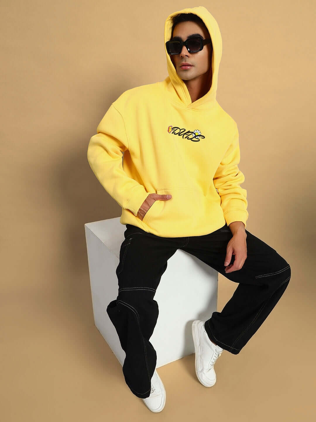 Model wearing CONFUSED FLEECE OVERSIZED HOODIE YELLOW with black pants and white shoes, showcasing streetwear style.