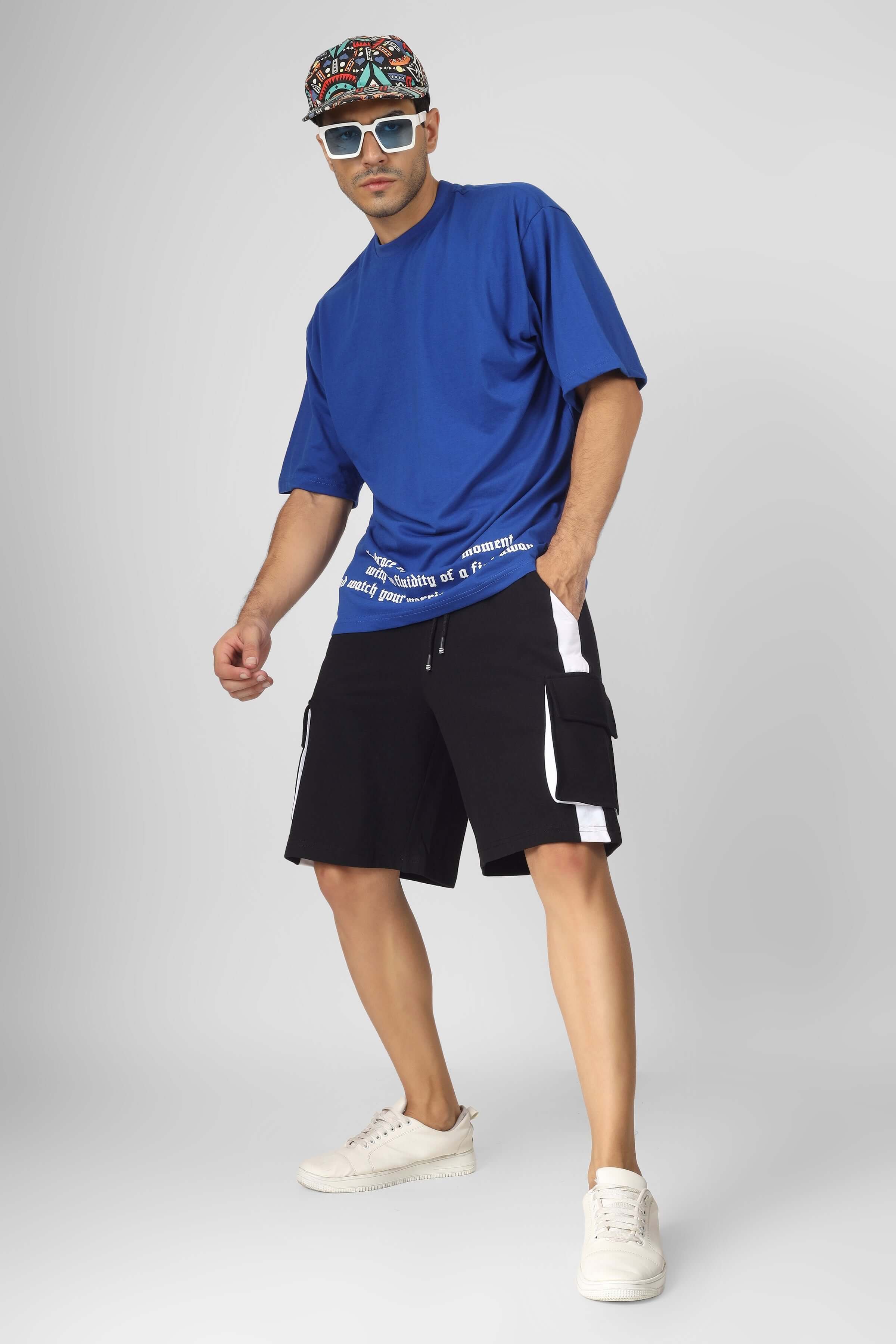 Model wearing CONTRA Regular Fit Cargo Shorts in black and white, paired with a blue t-shirt, showcasing urban casual style.