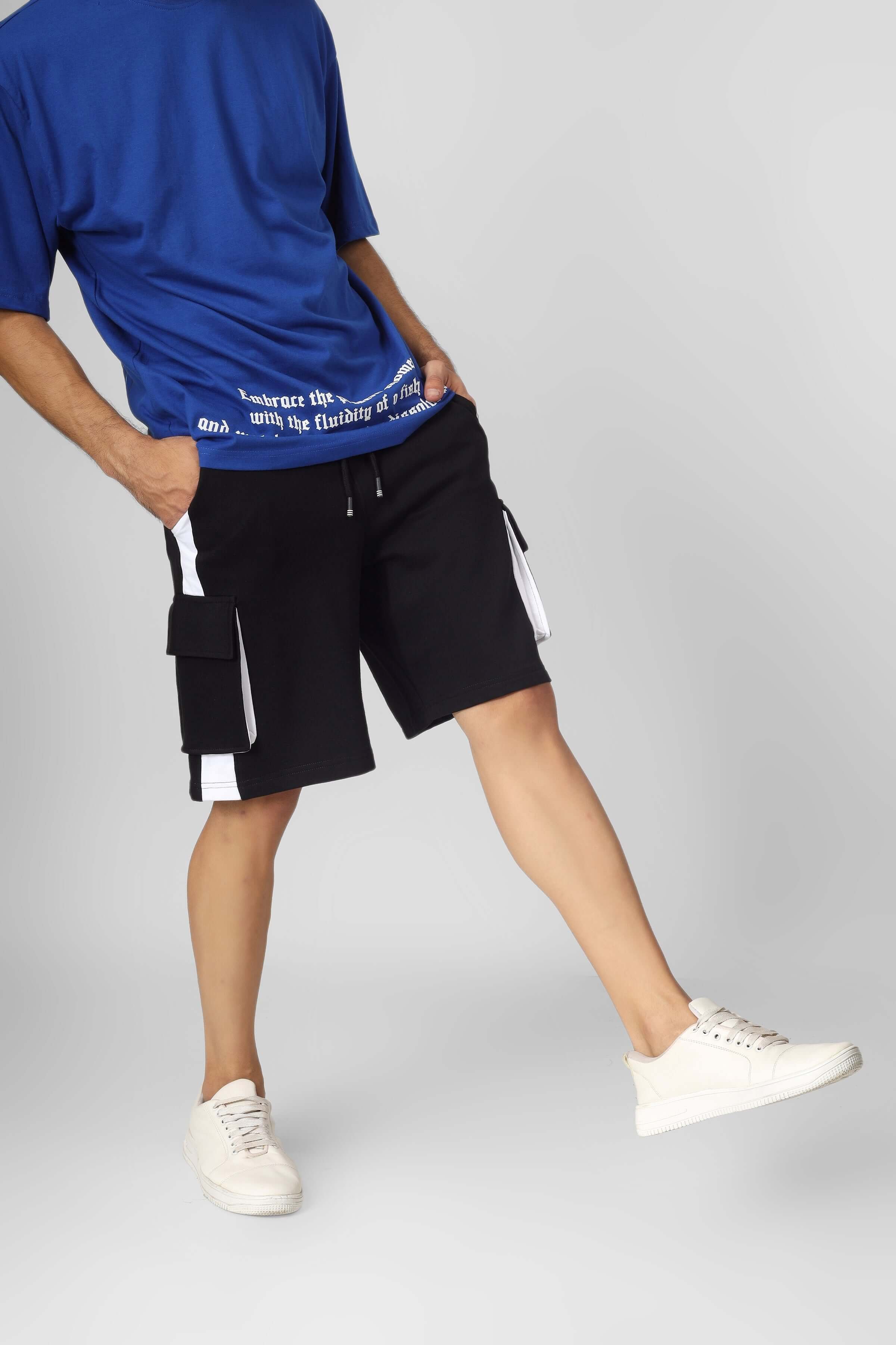 Person wearing CONTRA Regular Fit Cargo Shorts in Black & White with pockets, styled with a blue top and white sneakers.