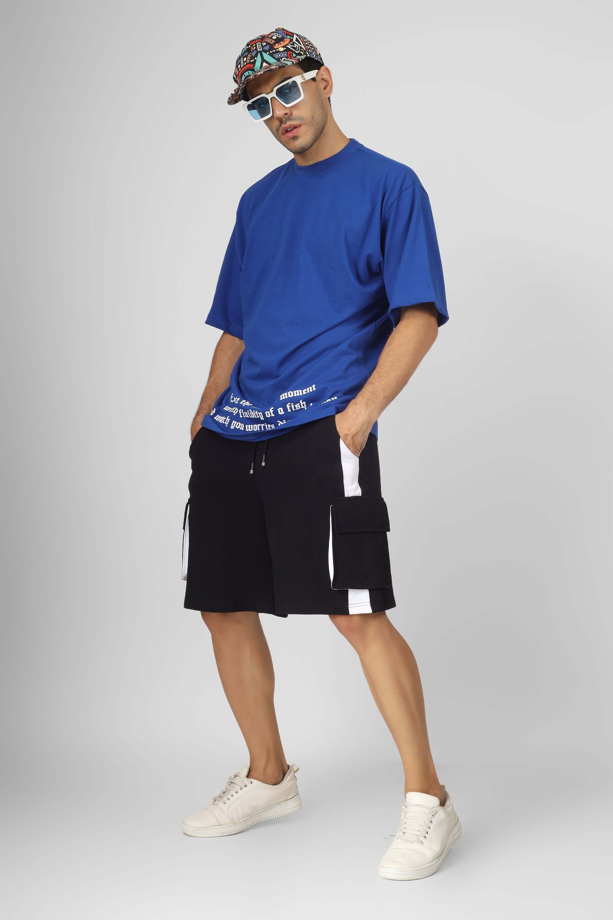 Model wearing Contra Regular Fit Cargo Shorts in black and white, paired with a blue t-shirt and sneakers, showcasing casual streetwear style.