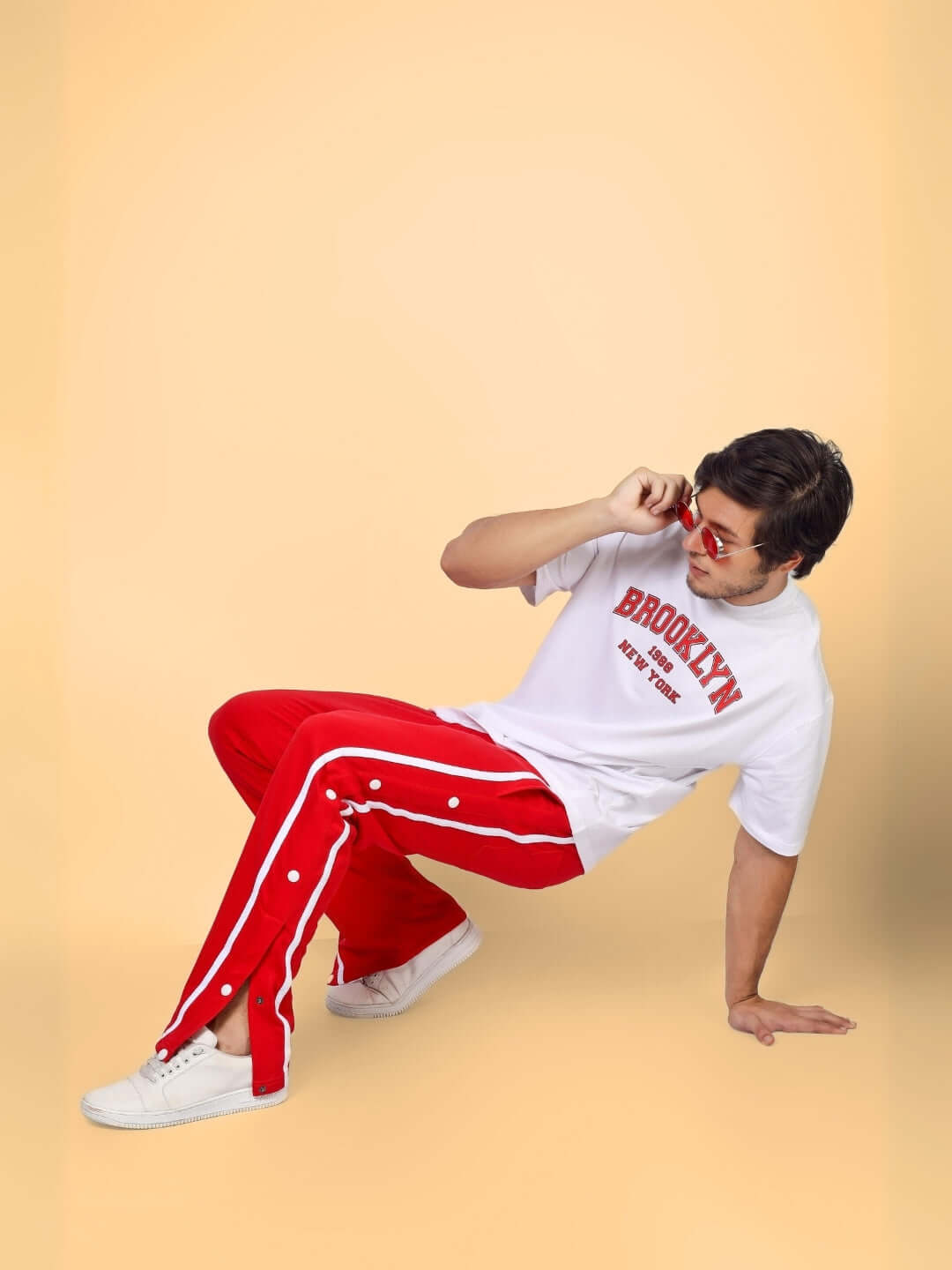 Person wearing red contrast panel joggers and white t-shirt, posing stylishly against a neutral background.