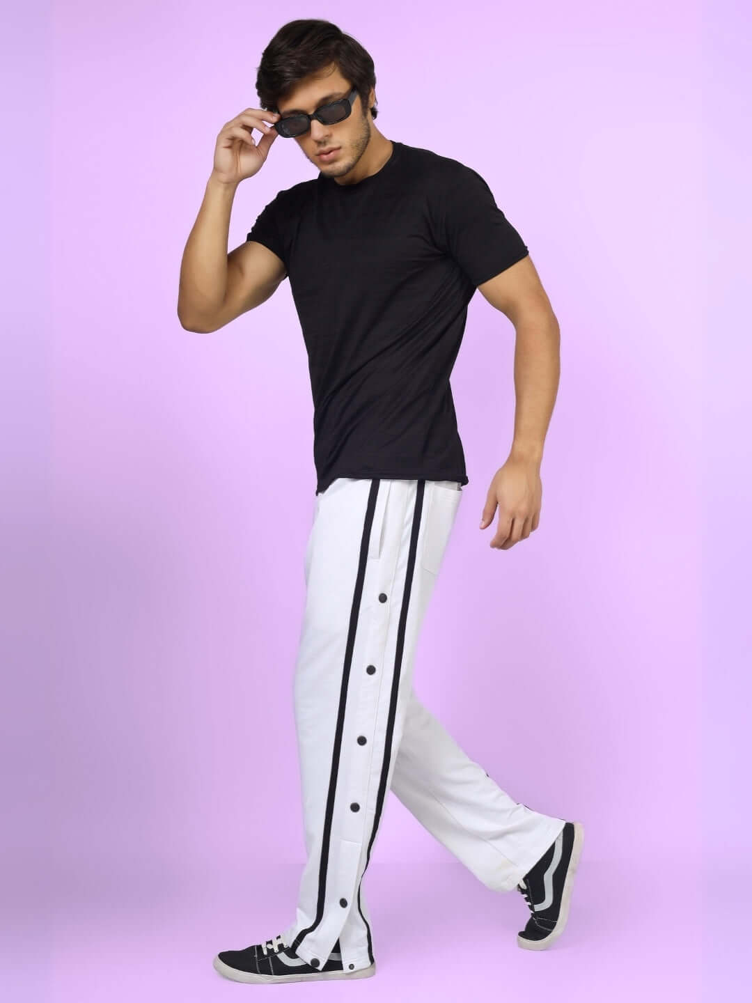 Model wearing contrast panel joggers in white with black stripe, walking confidently, portraying casual and trendy style by DUDS.