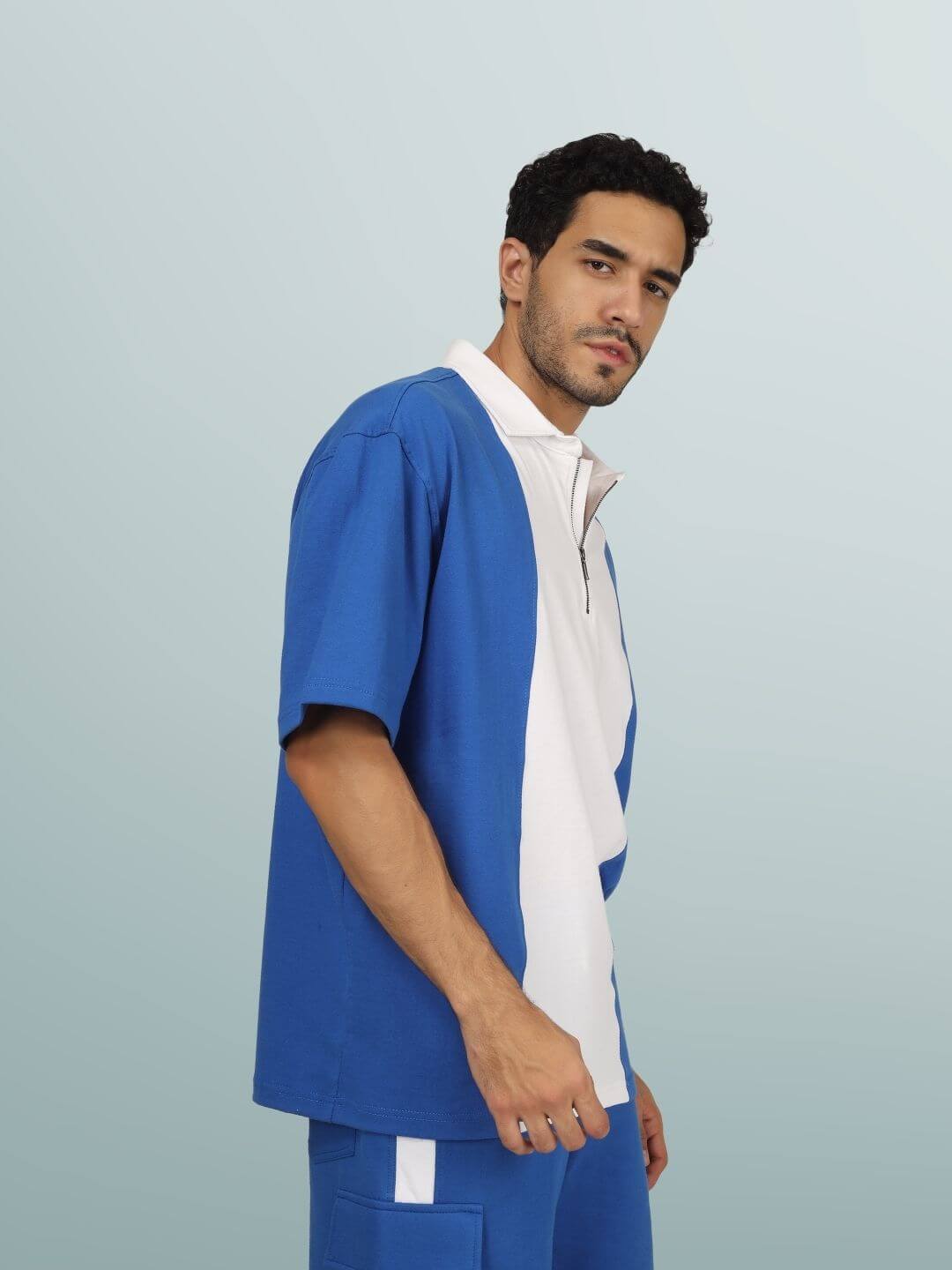 Model wears contrast polo oversized zipper t-shirt in royal blue and white, half sleeves, showing comfortable fit for all-day wear.
