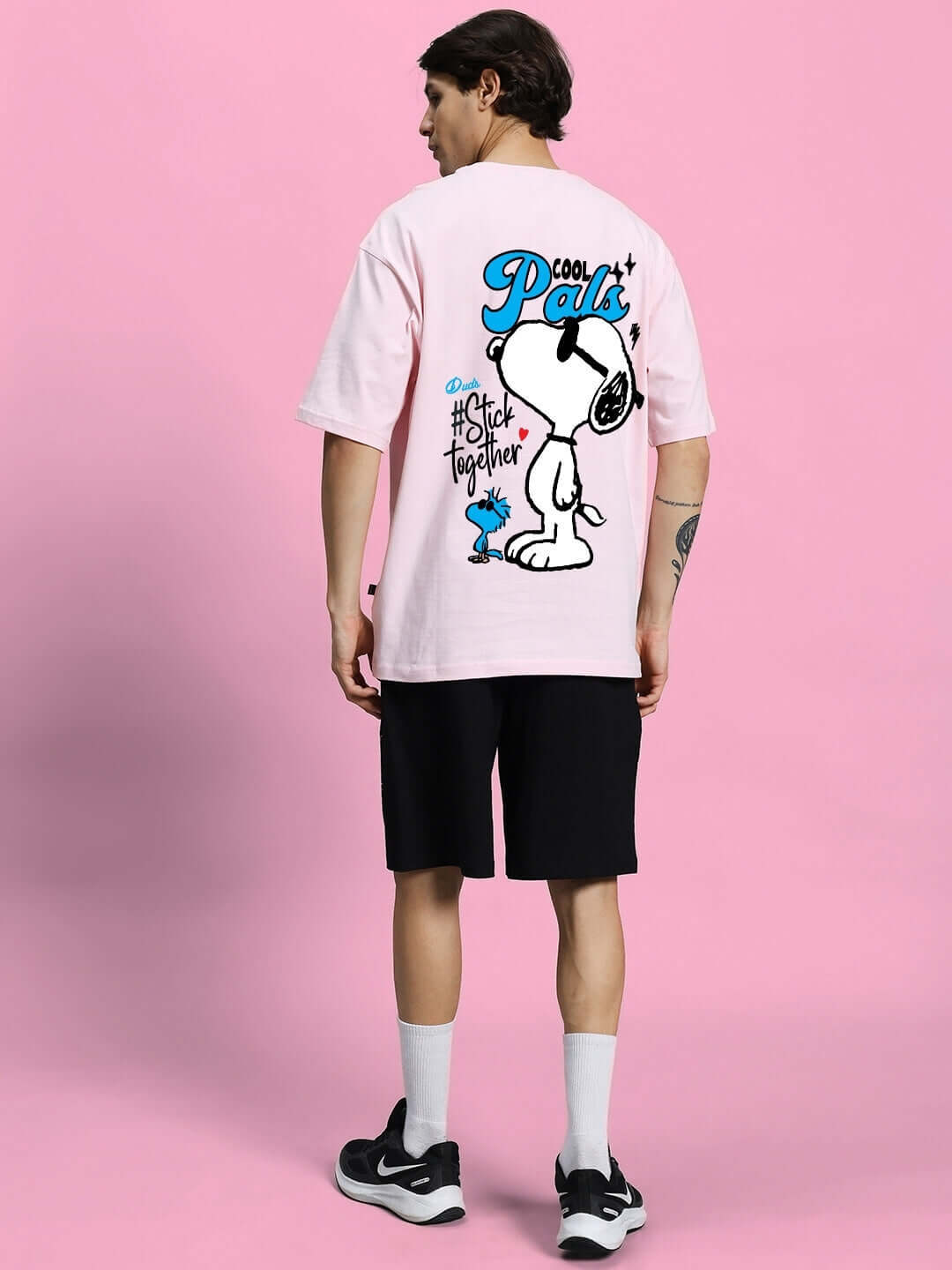 Person wearing COOL PALS SUMMER CO-ORD SET PINK BLACK with Snoopy graphic on pink t-shirt and black shorts, showcasing trendy summer fashion.