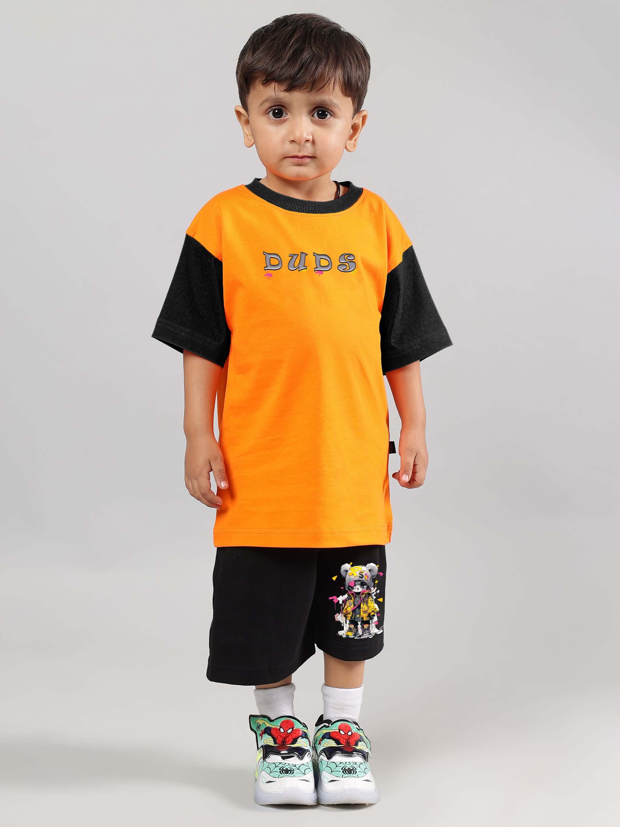Boy wearing orange-black COOL TEDDY CO-ORD set by DUDS, featuring a playful design, perfect for kids. Made to order, customizable size option.