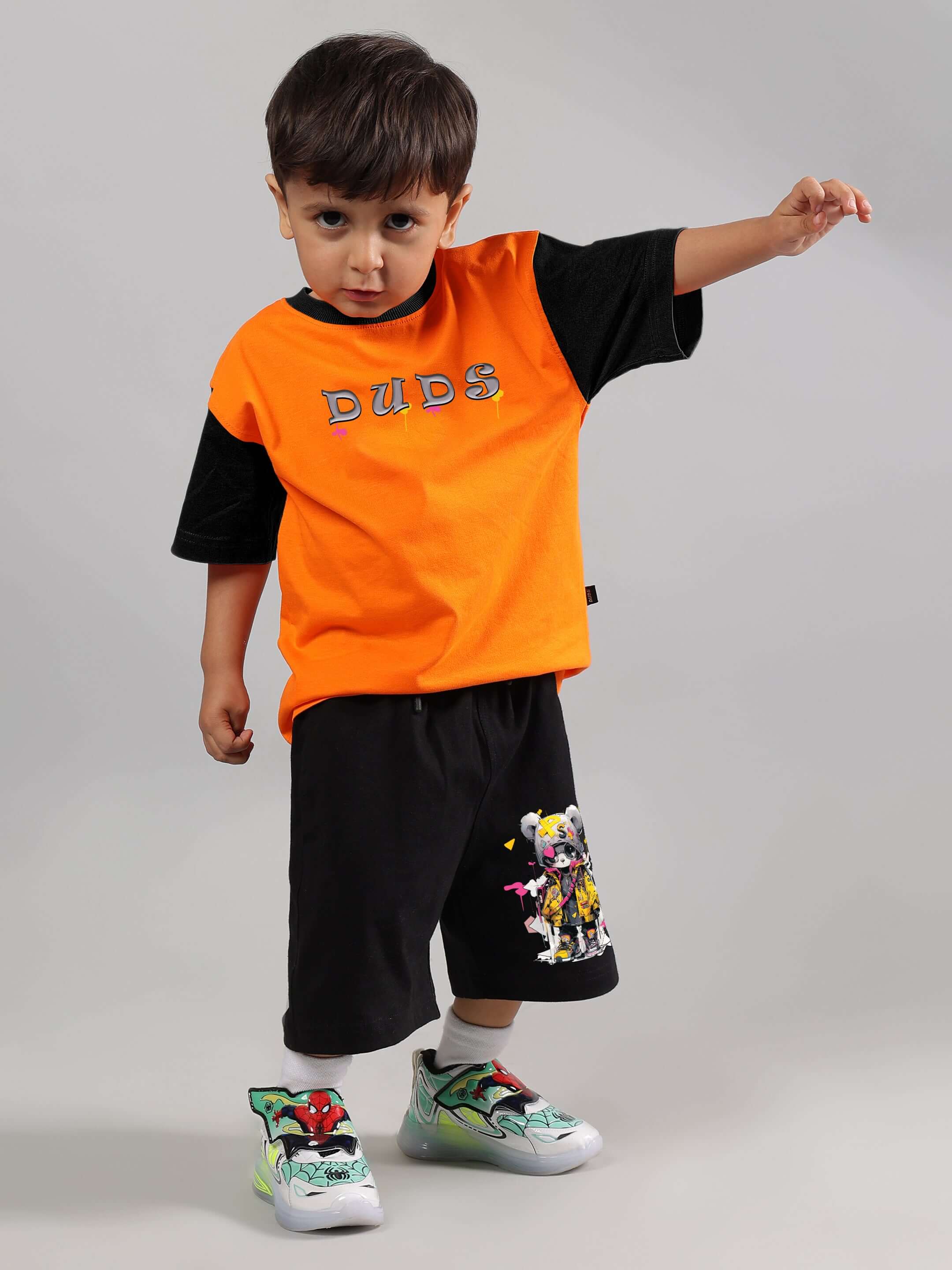 Child wearing COOL TEDDY co-ord set in orange and black by DUDS, showcasing playful design and casual fit.