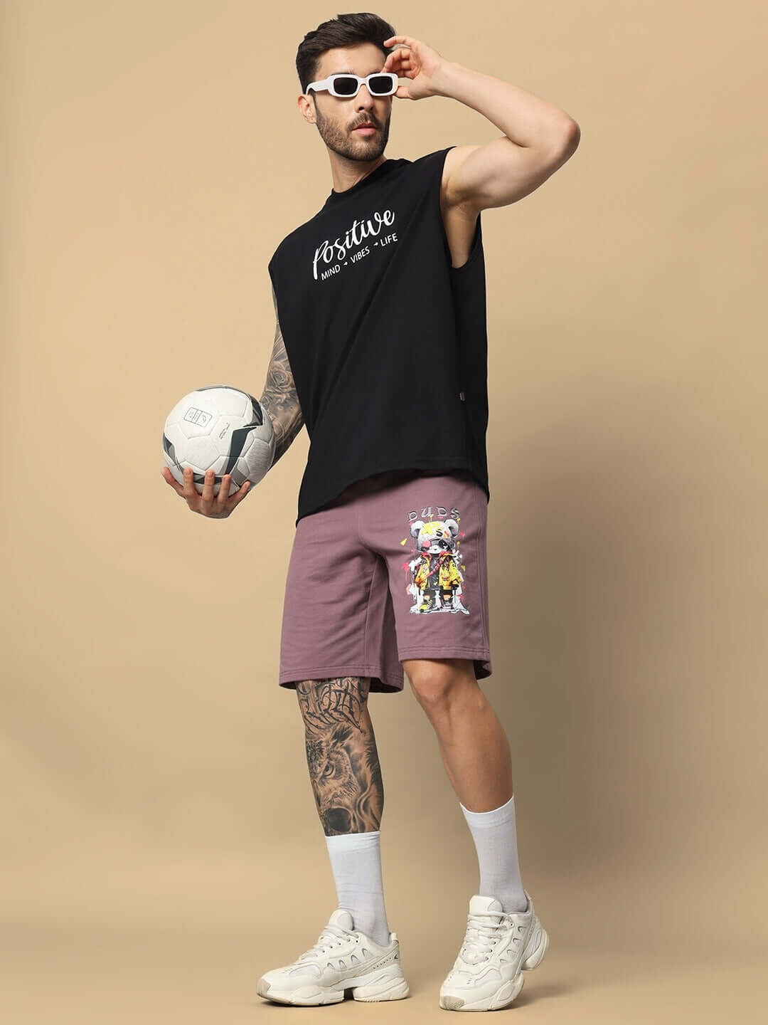 Model wearing COOL TEDDY Regular Fit Shorts in Chinese Violet, holding a soccer ball, showcasing sporty and casual style.