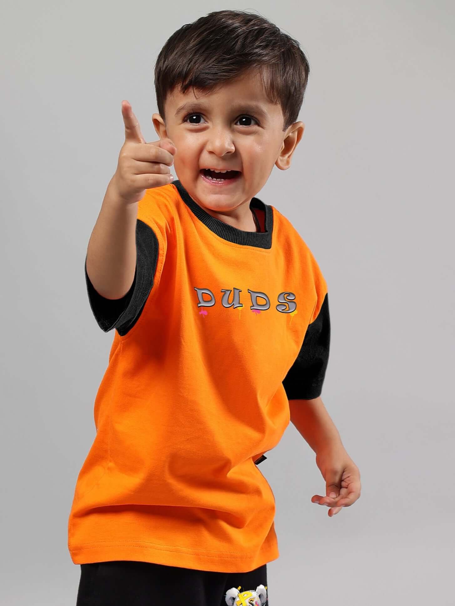 Child wearing orange COOL TEDDY T-SHIRT by DUDS, suitable for boys and girls, with black sleeves and playful design.