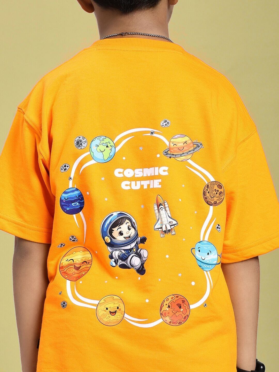 Child wearing COSMIC CUTE ASTRONAUT T-SHIRT FOR BOYS AND GIRLS ORANGE with astronaut and planets design on back.