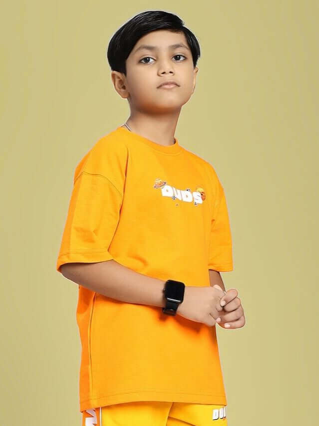 Child wearing COSMIC CUTE ASTRONAUT T-SHIRT FOR BOYS AND GIRLS ORANGE, displaying playful astronaut design on vibrant orange color.