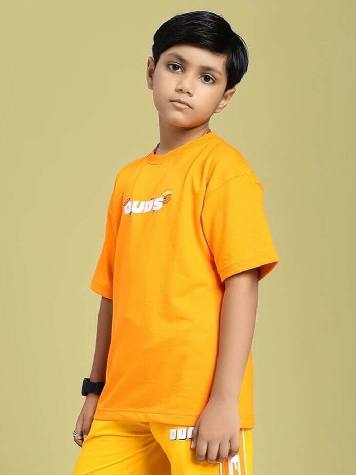 Young boy wearing orange cosmic cute astronaut t-shirt for boys and girls.