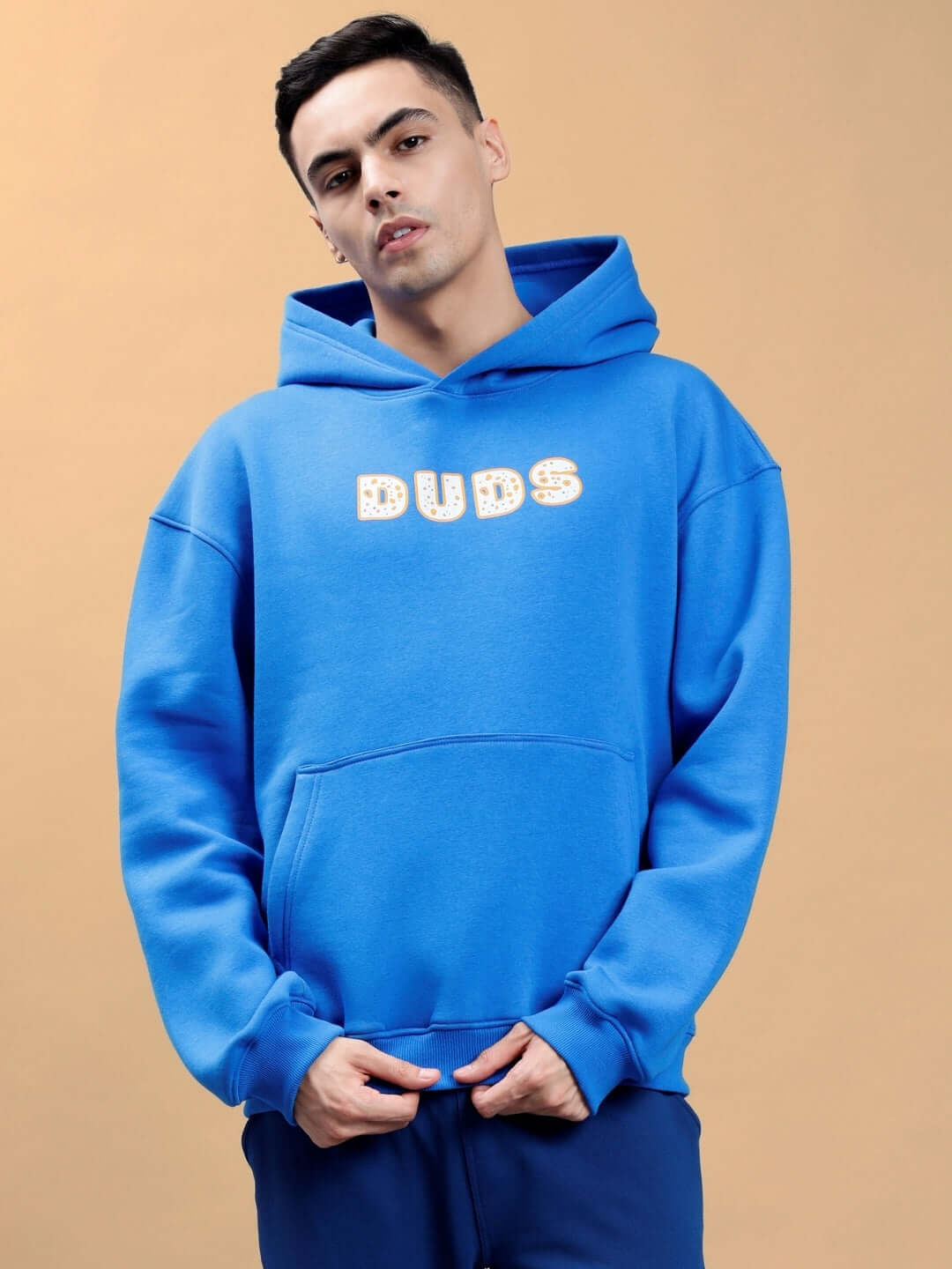 Person wearing Courage Oversized Hoodie in royal blue with 'DUDS' design, showcasing comfortable and stylish streetwear fashion.