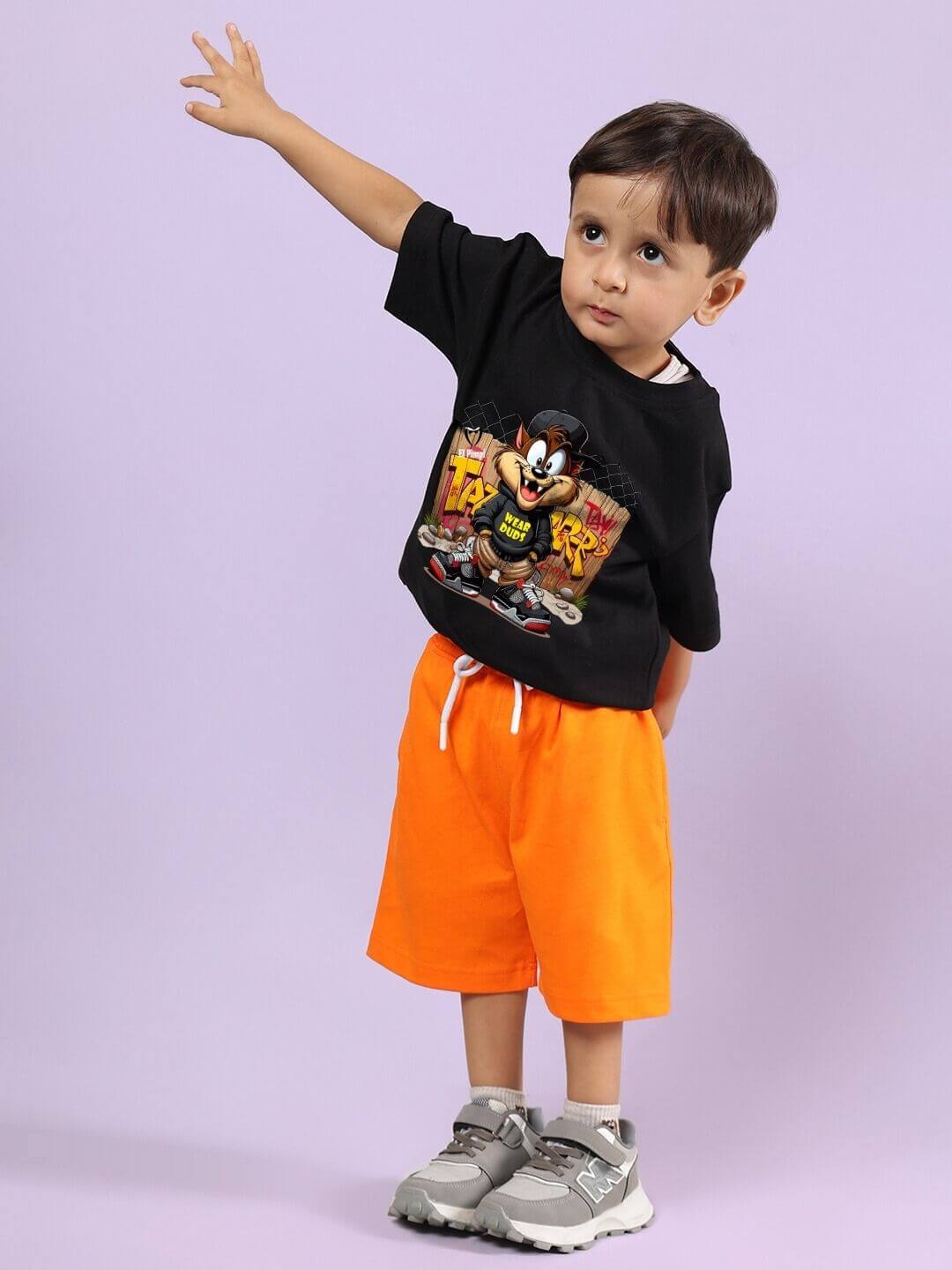 Child wearing CRAZY RAPPER T-SHIRT FOR BOYS AND GIRLS BLACK paired with orange shorts, showcasing a trendy streetwear style for kids.