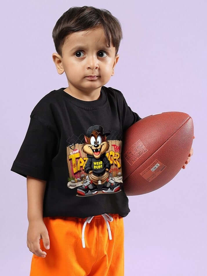 Child wearing CRAZY RAPPER T-SHIRT FOR BOYS AND GIRLS BLACK holding a football, showcasing trendy streetwear style for kids.