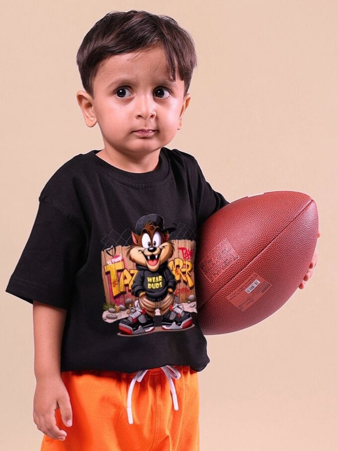 Young child wearing a Crazy Rapper black t-shirt holding a football, showcasing urban street style fashion for kids.
