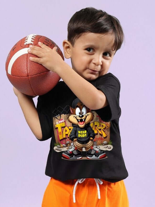 Boy wearing CRAZY RAPPER T-SHIRT FOR BOYS AND GIRLS BLACK holding a basketball, featuring streetwear-inspired cartoon design.