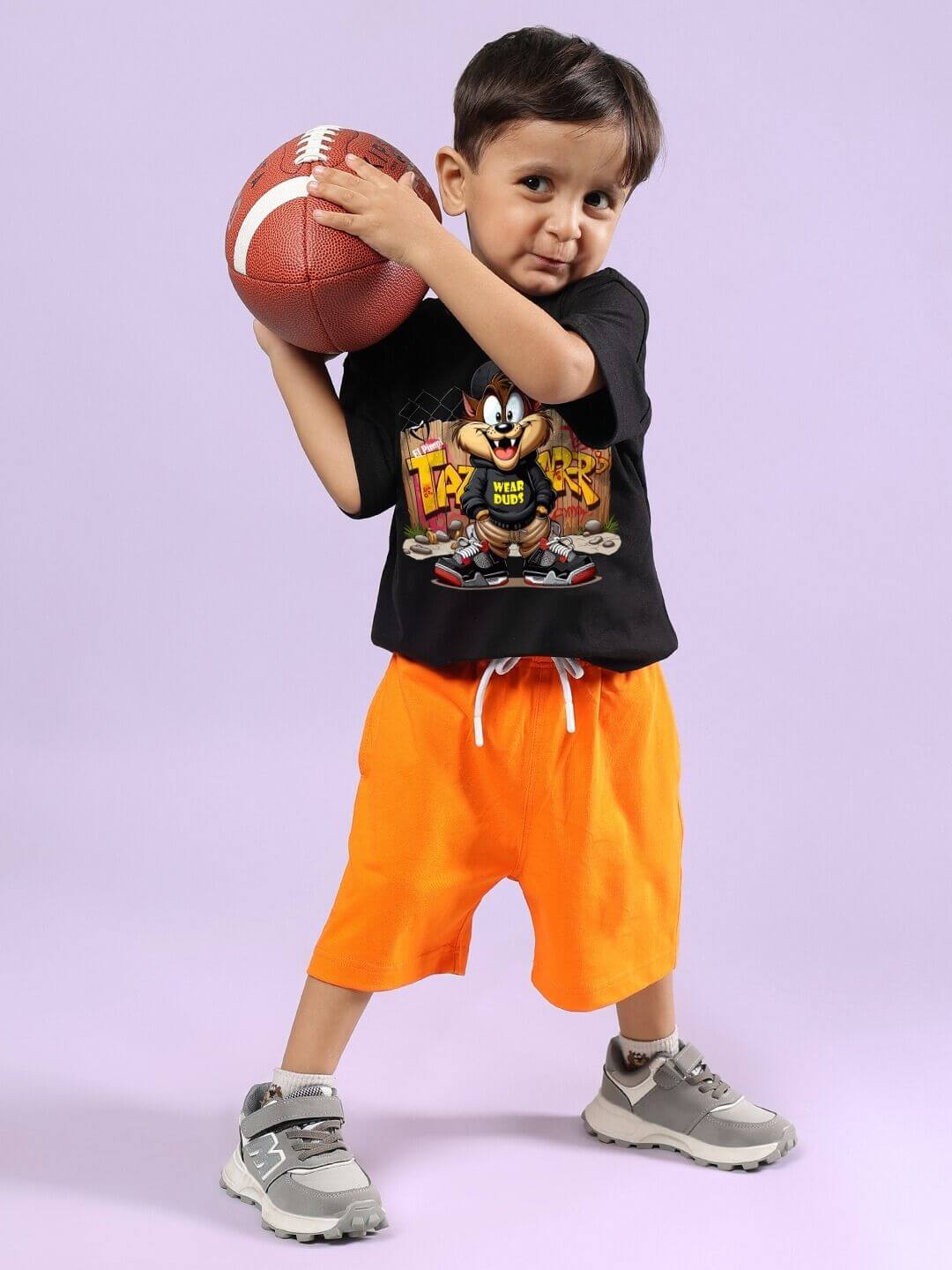 Child wearing CRAZY RAPPER CO-ORD FOR BOYS GIRLS AND BLACK-ORANGE holding a football.