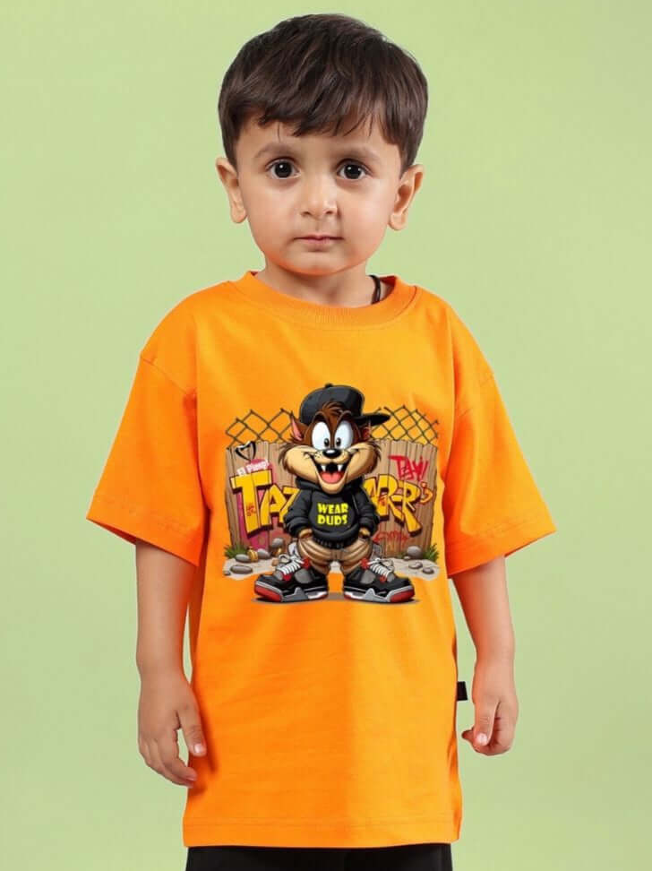 Child wearing CRAZY RAPPER T-SHIRT FOR BOYS AND GIRLS ORANGE with cartoon print, styled against a green background.