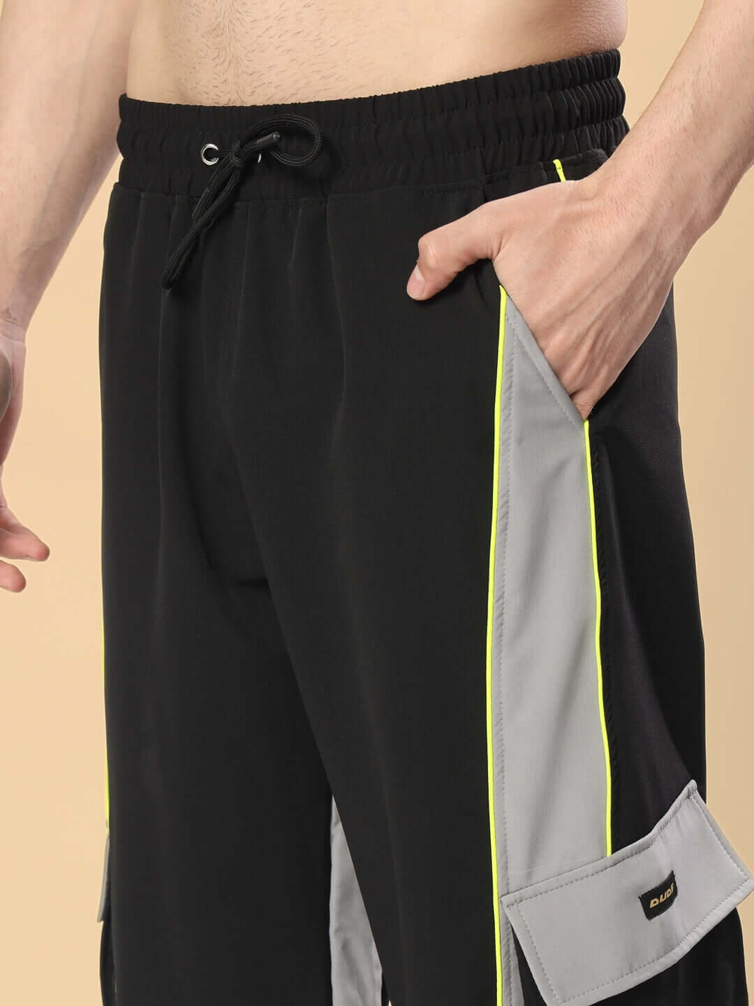 Black-grey relaxed fit cargo pants featuring custom fit option and neon accents, perfect for casual wear.