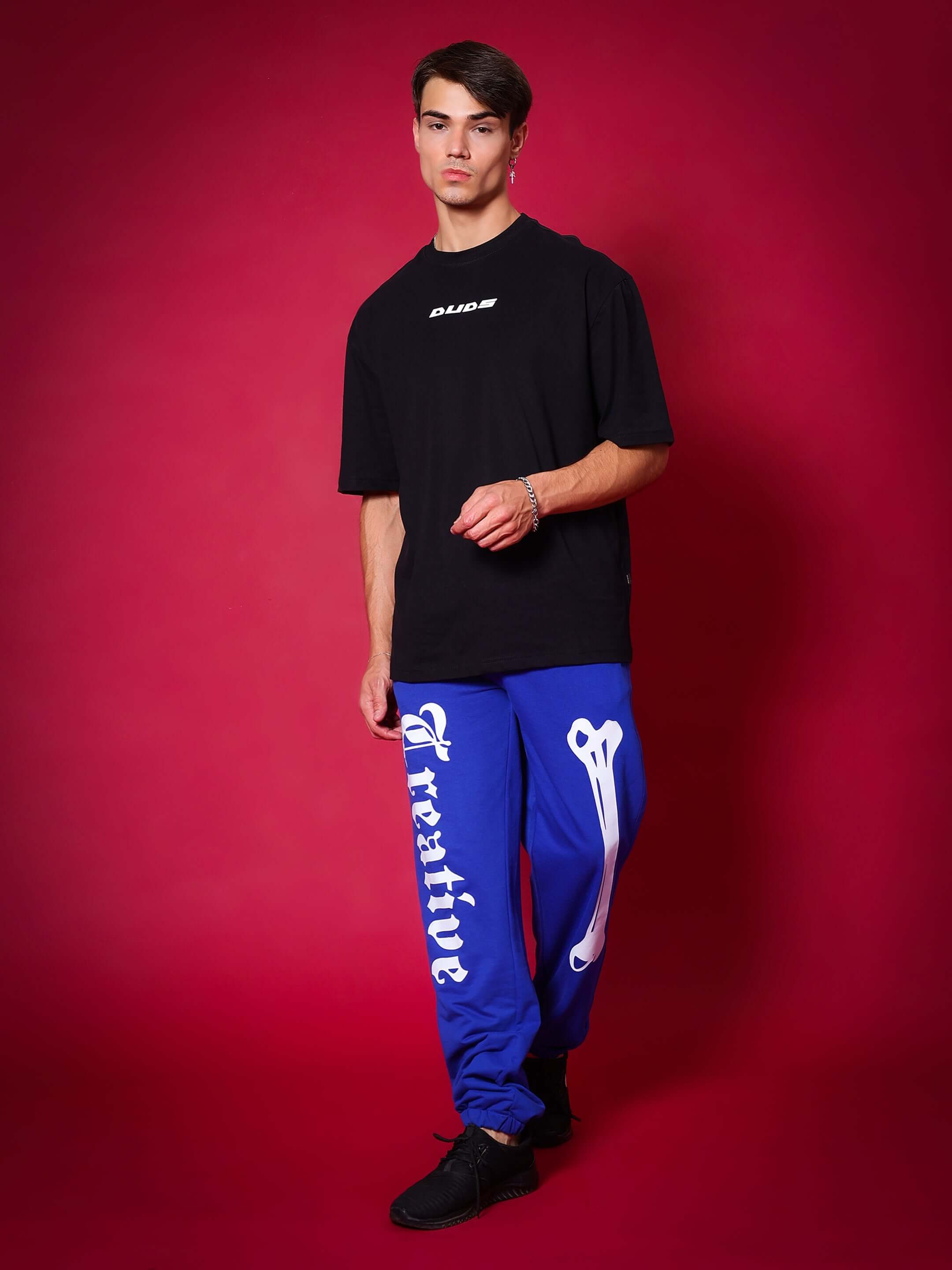 Model wearing royal blue Creative Relaxed Pant Jogger by DUDS, showcasing bold streetwear style.