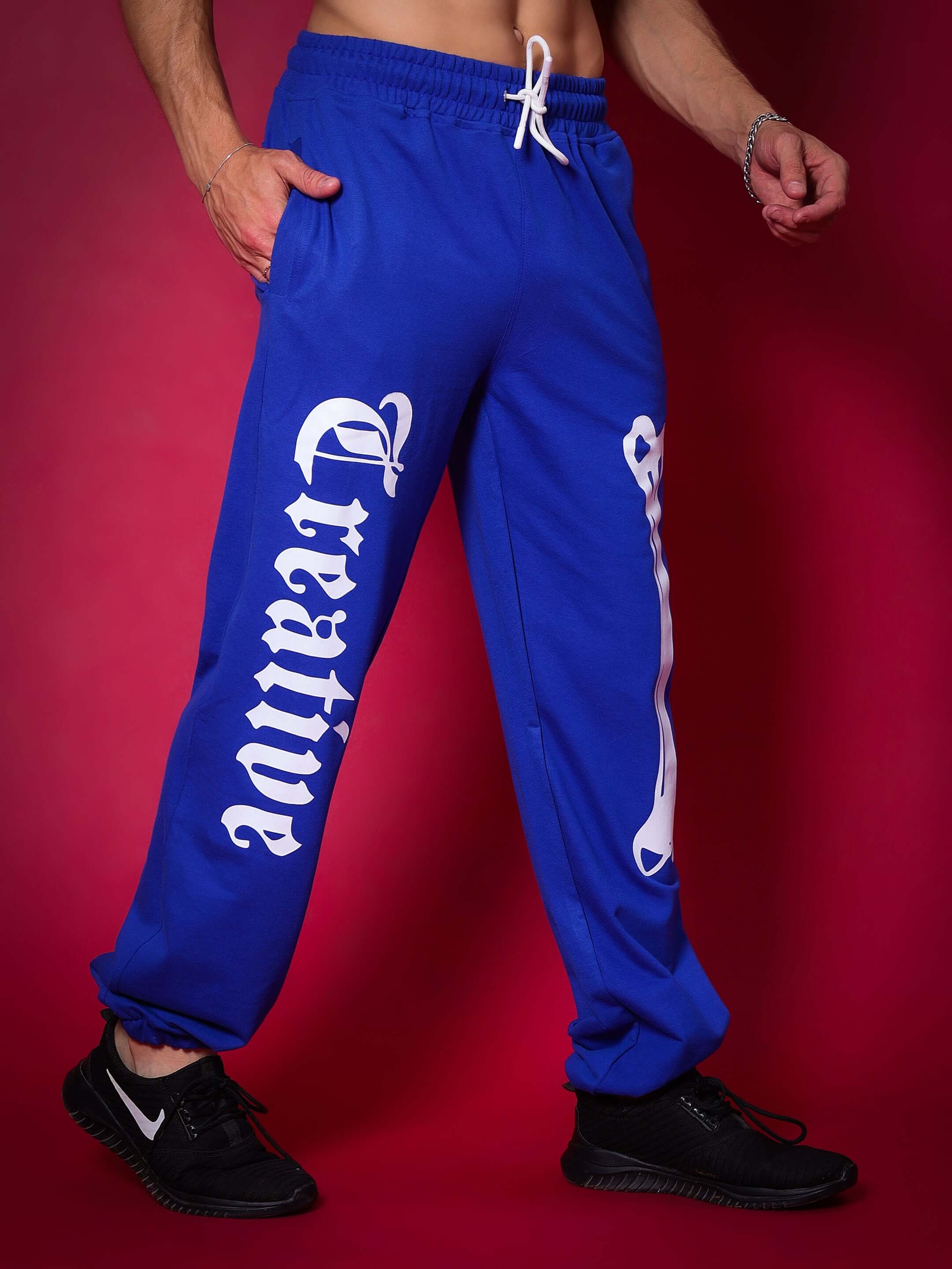 Royal Blue Creative Relaxed Pant Jogger worn by model, featuring casual fit, side pockets, and drawstring waist against a red background.