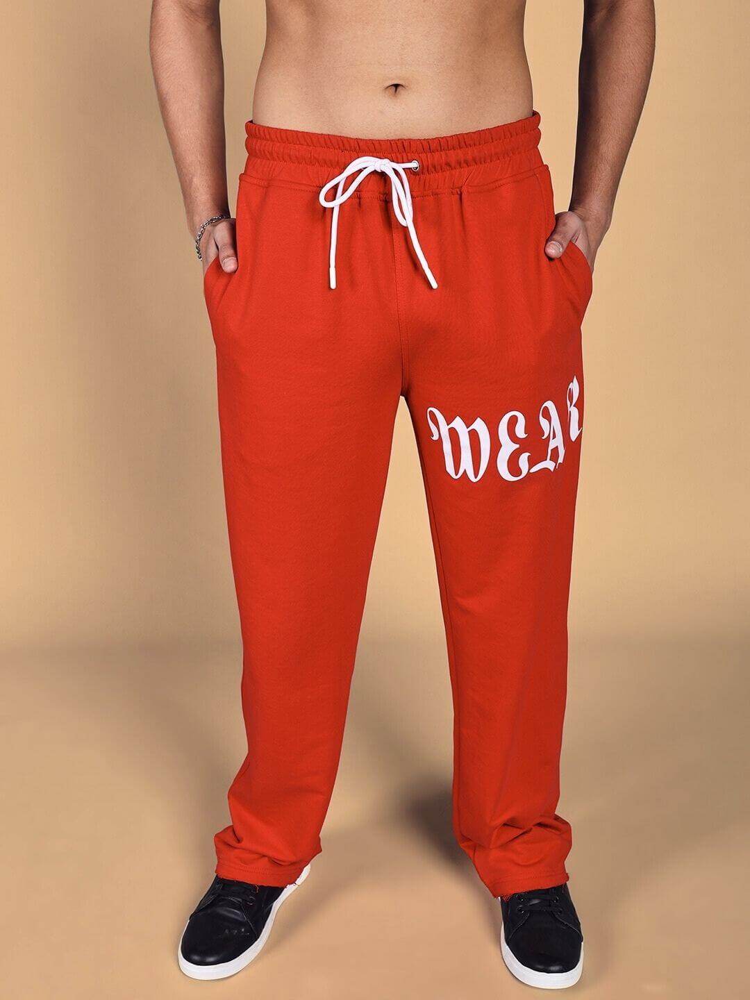 Man wearing crimson relaxed fit joggers with white drawstrings and 'WEAR' printed, showcasing casual style suitable for customization.