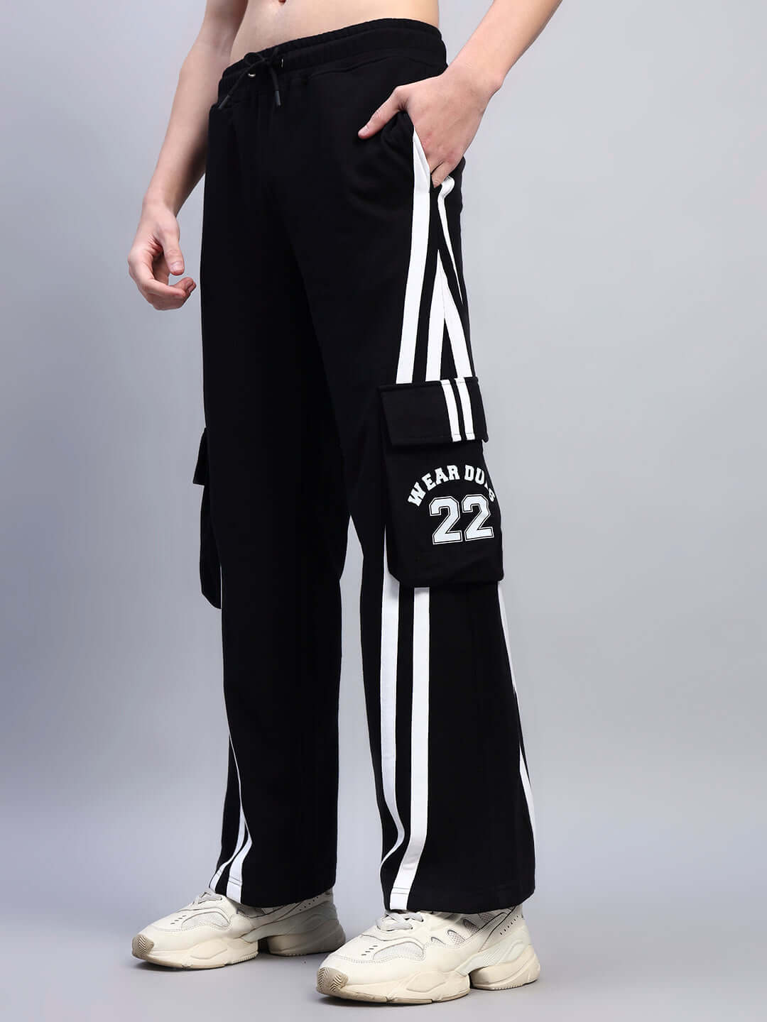 Model wearing black relaxed-fit joggers with multi pockets and white stripes, emphasizing casual style and comfort.