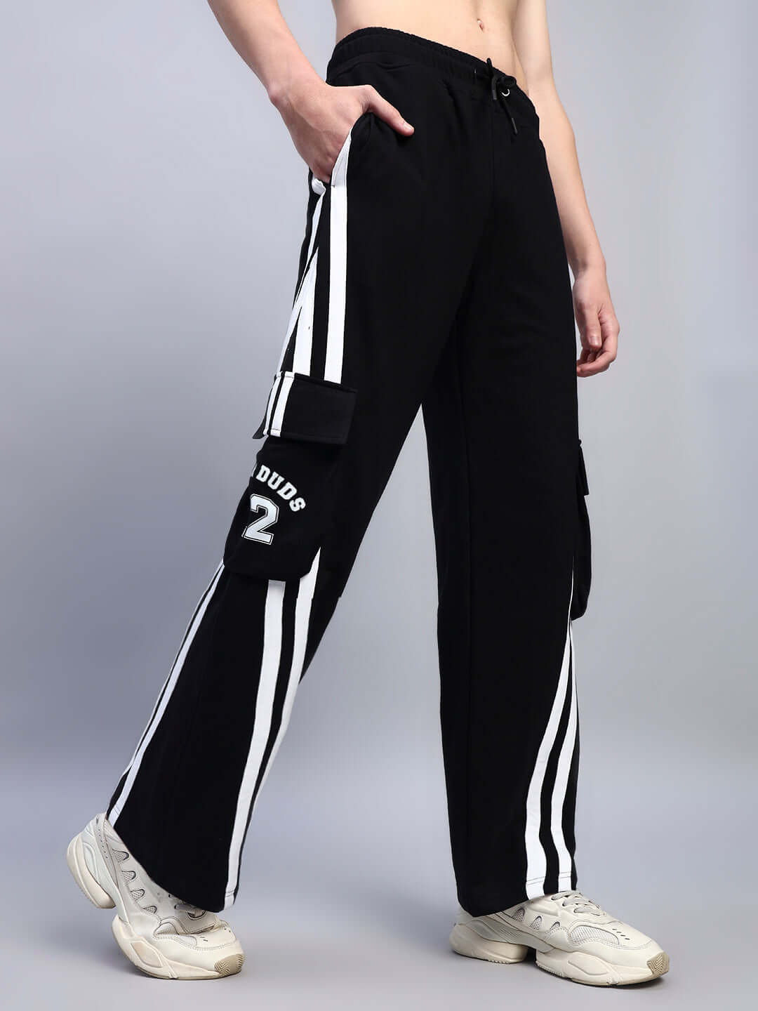 CRUCIS black joggers with multiple pockets, relaxed fit, and white stripes, worn by model. Comfortable and customizable by DUDS.