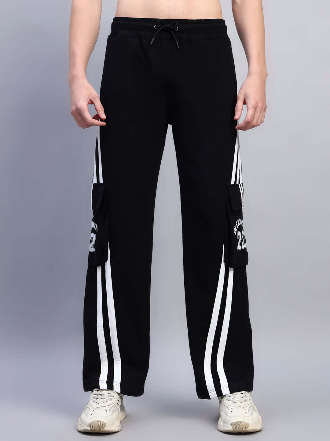Person wearing CRUCIS black relaxed-fit joggers with multi pockets and white stripes.