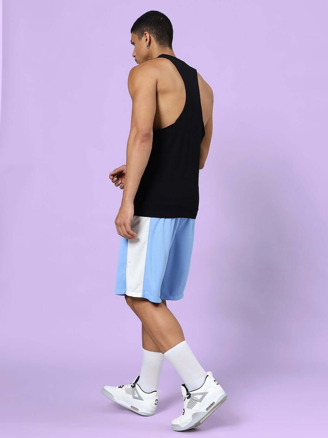 CRUNCH GYM CO-ORD SET BLACK-BLUE with man wearing black tank top and blue shorts against a purple background