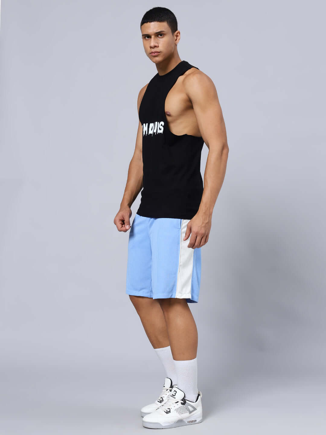 Model wearing CRUNCH REGULAR FIT SHORTS BLUE with sporty tank top and sneakers.