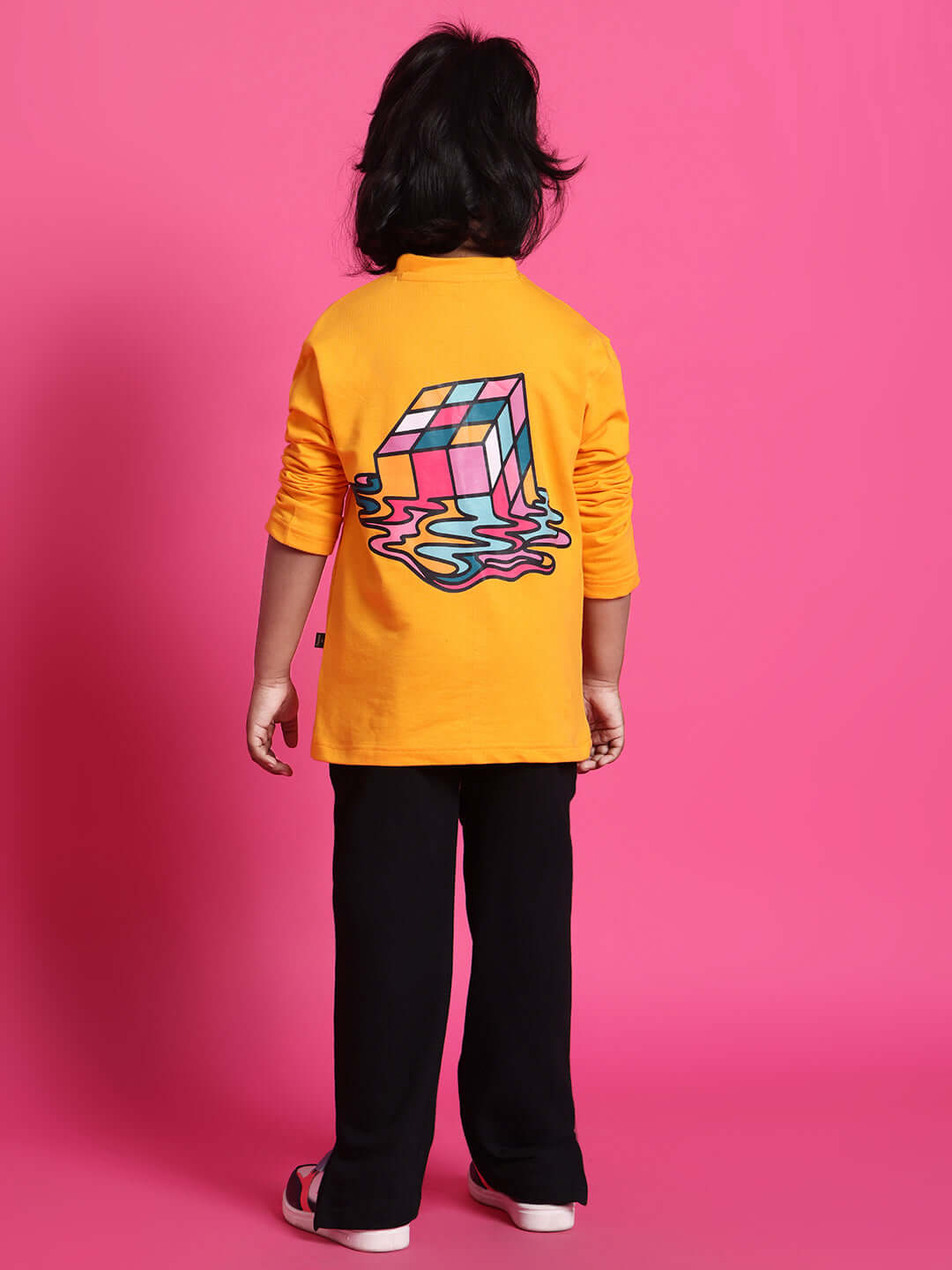 Child wearing a yellow and black cube co-ord with a colorful melting cube design on the back, suitable for boys and girls.