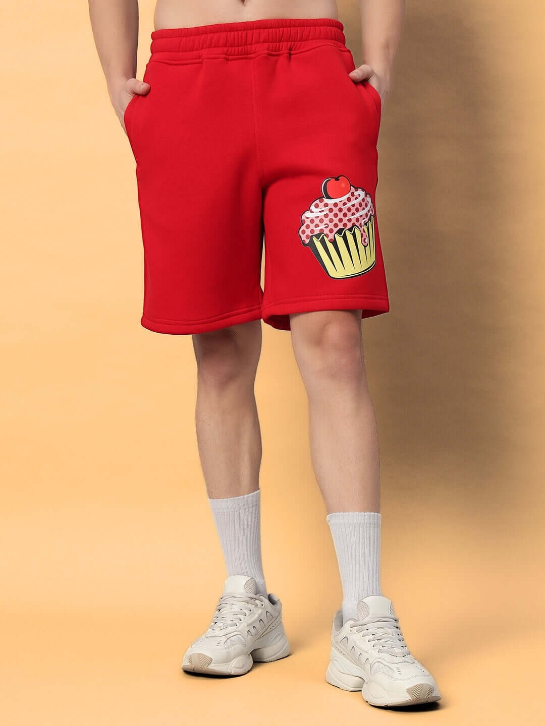 Model wearing CUPCAKE COTTON FLEECE SHORTS RED with cupcake design, standing against a neutral background.