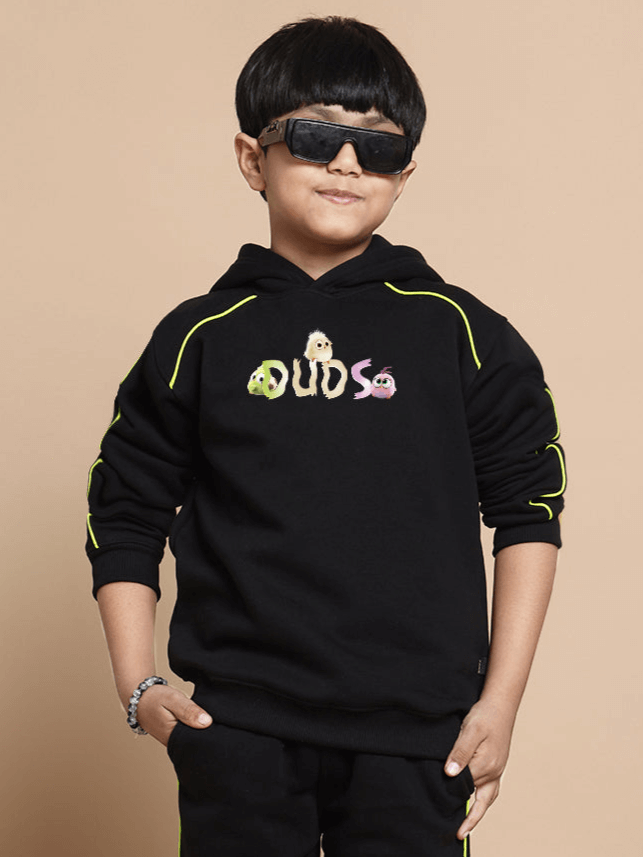 Child wearing CUTE ANGRY BIRD OVERSIZED HOODIE BOYS & GIRLS BLACK with DUDS logo, sunglasses, and hands in pockets.