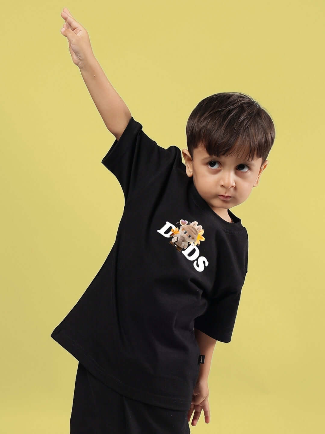 Child wearing Cute Monsters T-Shirt for Boys Girls Black with playful monster design on a yellow background.