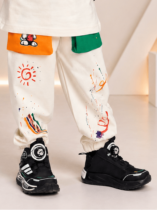 CUTE PUPPY JOGGER FOR BOYS AND GIRLS OFF WHITE MULTI with colorful patches and stylish black sneakers.