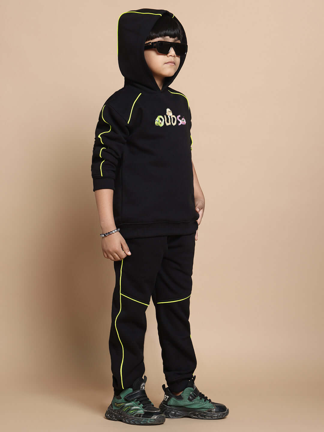 Child wearing black Angry Bird co-ord set with neon accents, hooded sweatshirt and pants, suitable for boys and girls.