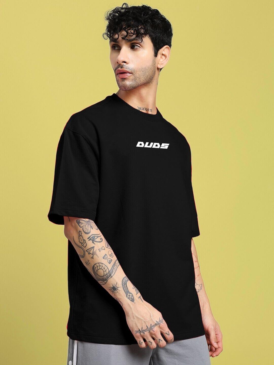 Model wearing a CYBERPUNK OVER-SIZED T-SHIRT BLACK with graphic detailing on a yellow background.