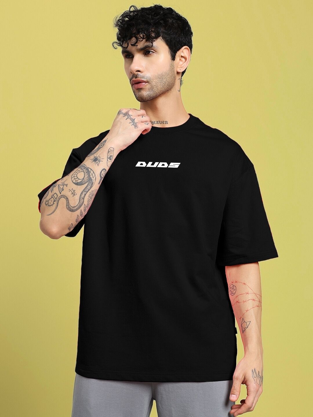 Model wearing CYBERPUNK OVER-SIZED T-SHIRT BLACK with graphic details, showcasing futuristic street style and relaxed fit.