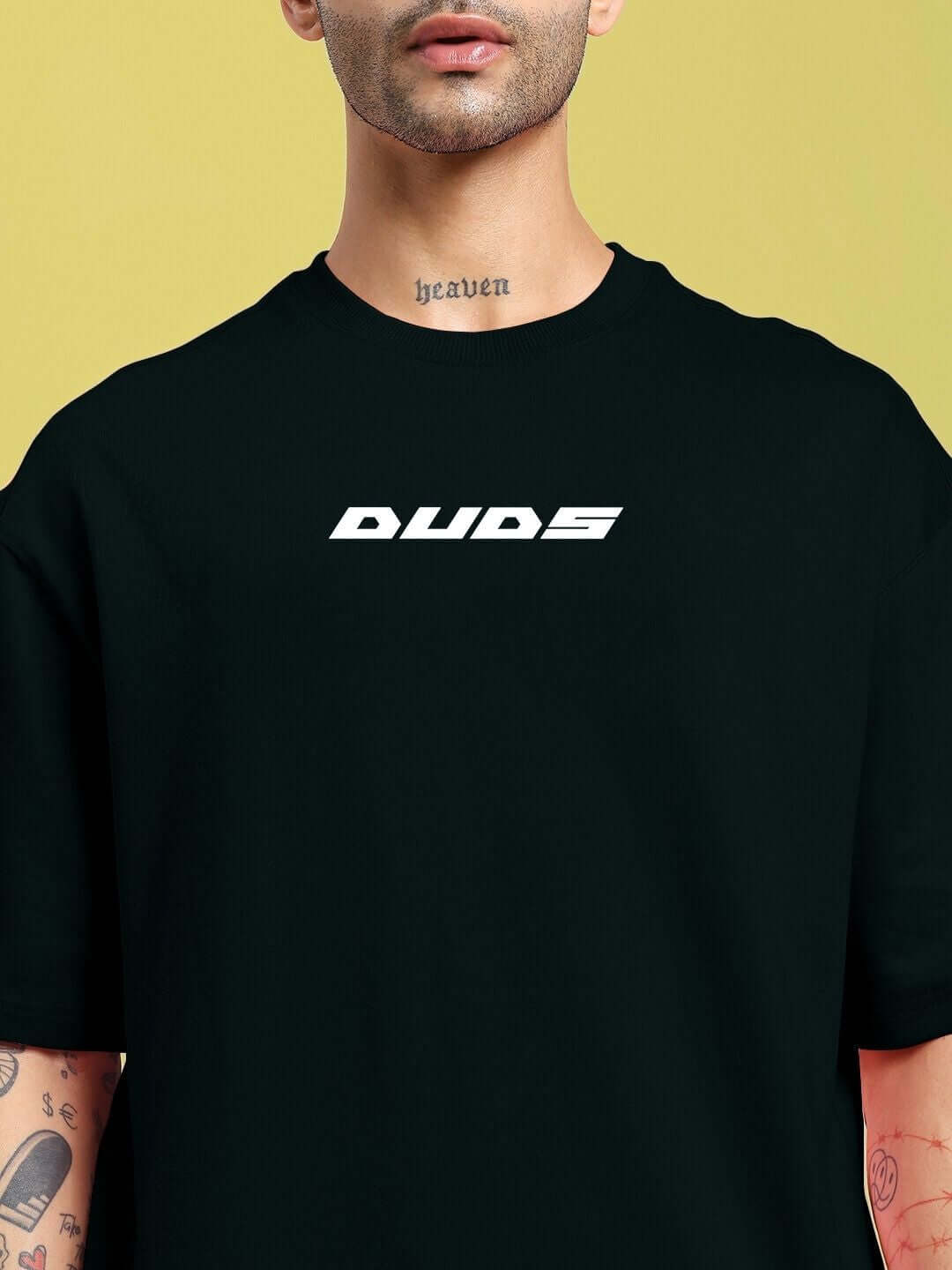 Model wearing CYBERPUNK OVER-SIZED T-SHIRT BLACK with sleek graphics and tattoos, perfect for edgy street style.