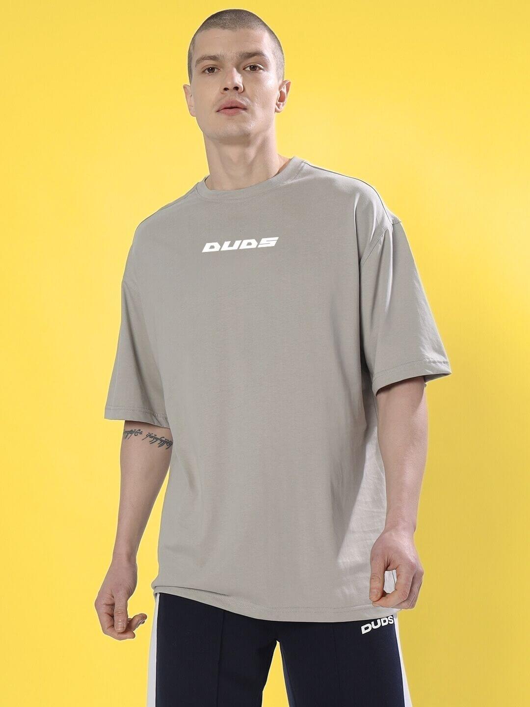 CYBERPUNK OVER-SIZED T-SHIRT GREY on man, futuristic urban fashion, relaxed fit, soft grey hue, streetwear style, bold statement piece.