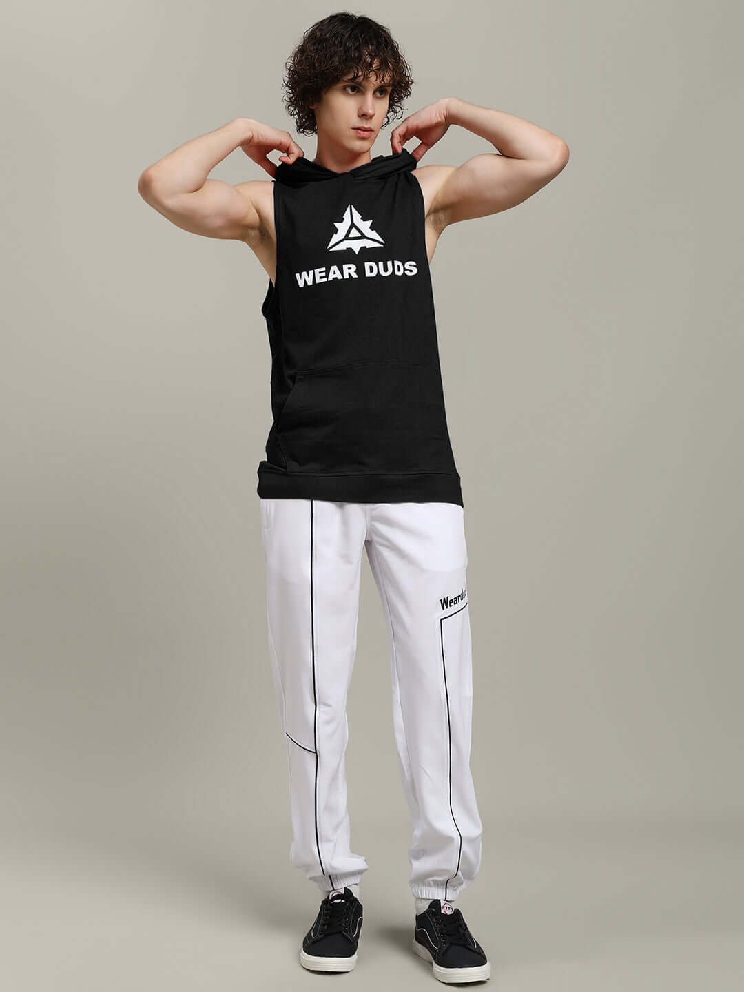Person wearing CYBRAN GYM Hooded T-Shirt in black with logo, styled for fitness, paired with white joggers and sneakers.