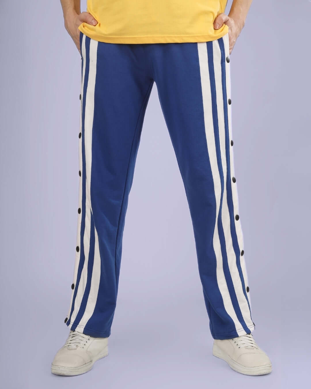 Person wearing royal blue DANCER JOGGERS with white stripes; customizable fit made by DUDS Tailors, shipping in 7-10 days.
