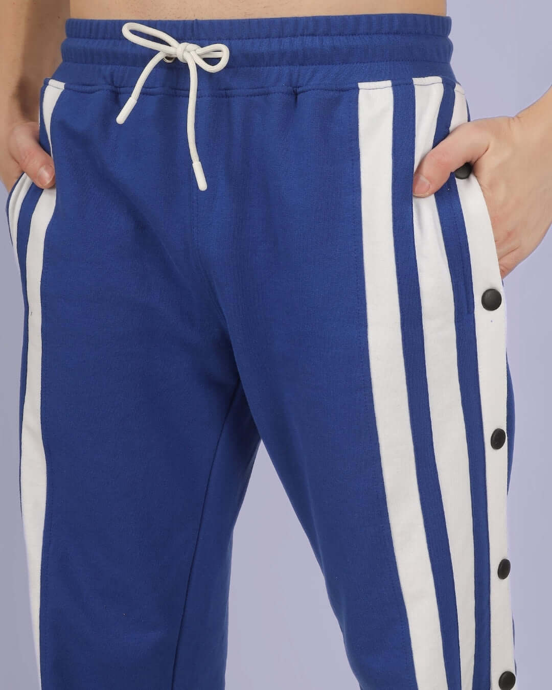Royal blue joggers with white stripe detailing, adjustable drawstring, and side buttons, crafted by DUDS for made-to-order comfort.