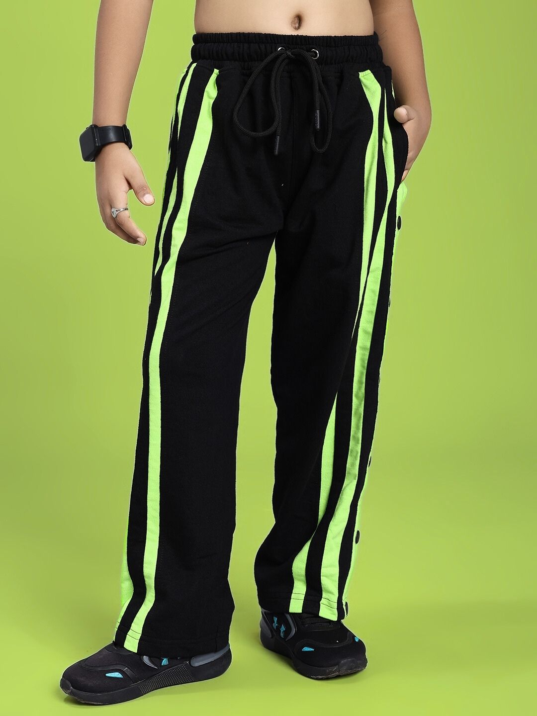 Child wearing DANCER JOGGER FOR BOYS AND GIRLS BLACK NEON-GREEN, featuring relaxed fit with neon-green accents for active kids.