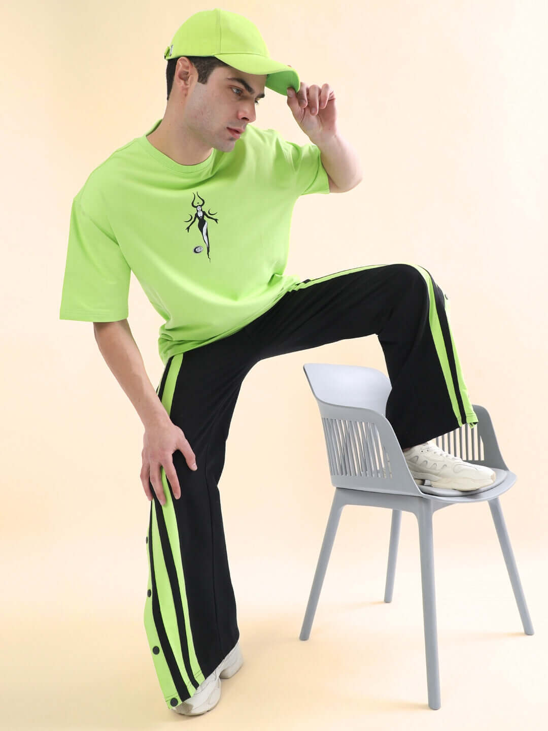 Model wearing Dancer Joggers in black-neon green with matching shirt and cap, showcasing trendy urban style.
