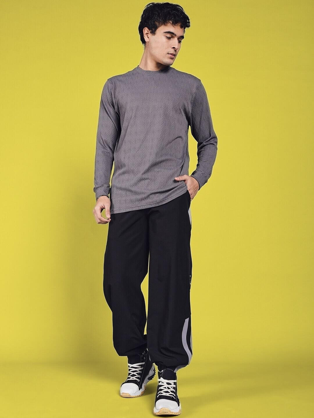 Model wearing DANNY Relaxed Fit Cargo Pants in black with customizable sizing option, paired with a grey long-sleeve shirt.