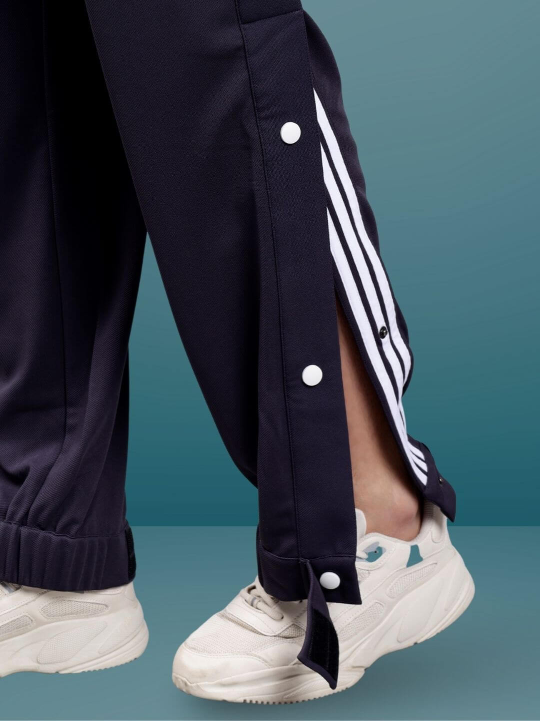 Dark steel grey hip hop joggers with ankle straps and side buttons, paired with white sneakers. Ideal for custom fit options.