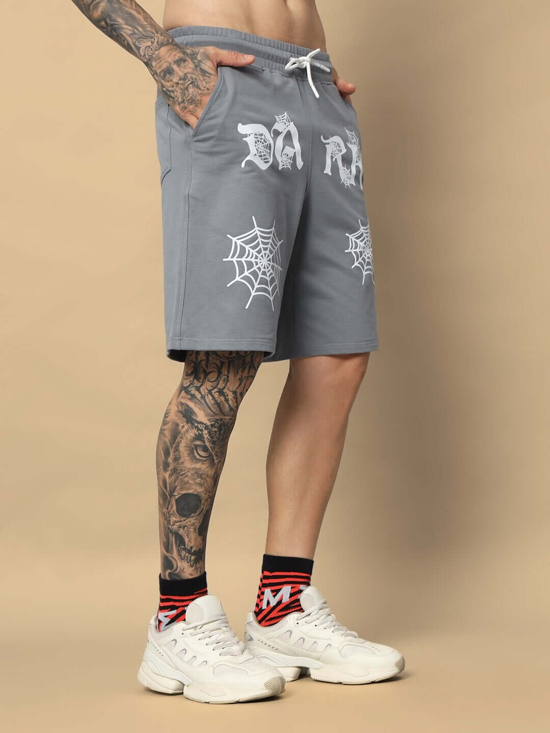 Model wearing grey Dark Web regular fit shorts with web design, showcasing casual comfort and style.