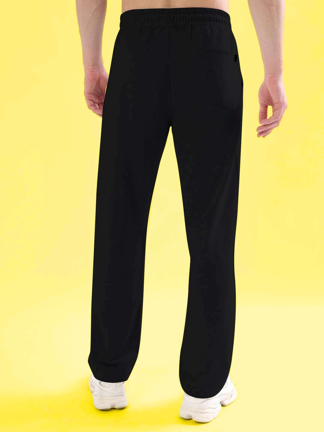 Man wearing DARK WEB Relaxed Jogger in black, showcasing comfortable fit and sleek design on a bright yellow background.